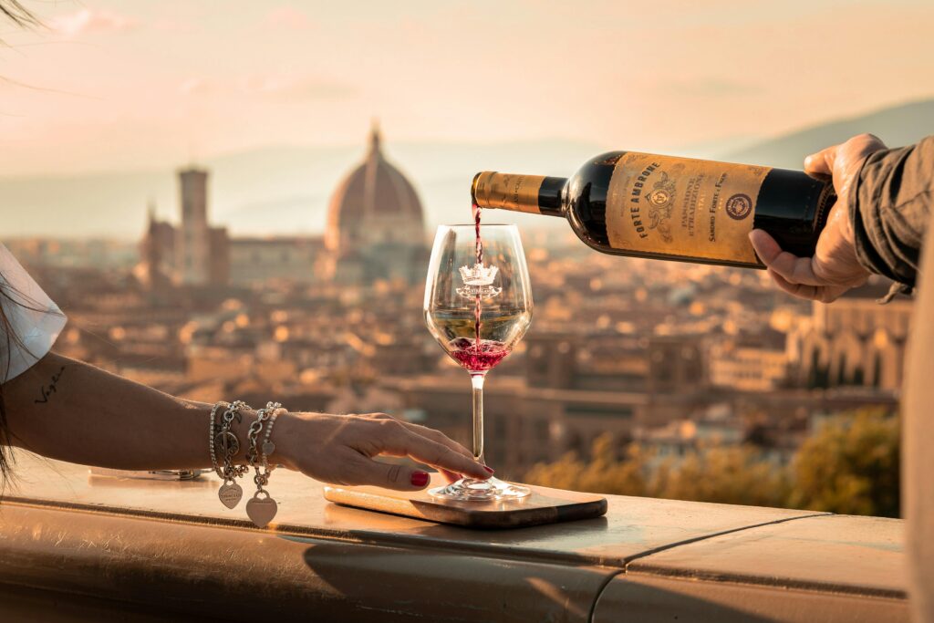 Pouring Wine to Woman Glass in Sunlight and with Florence behind
